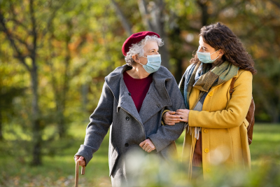 Caregiver helping elderly while walking