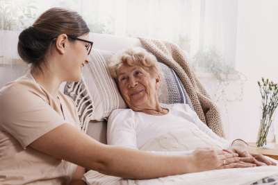 caregiver and elderly smiling at each other