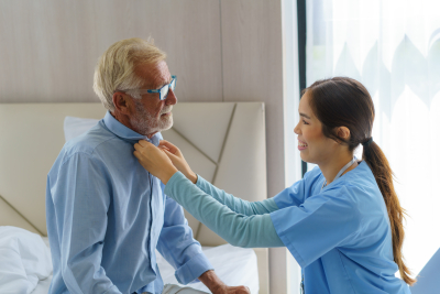 Caregiver dressing elderly